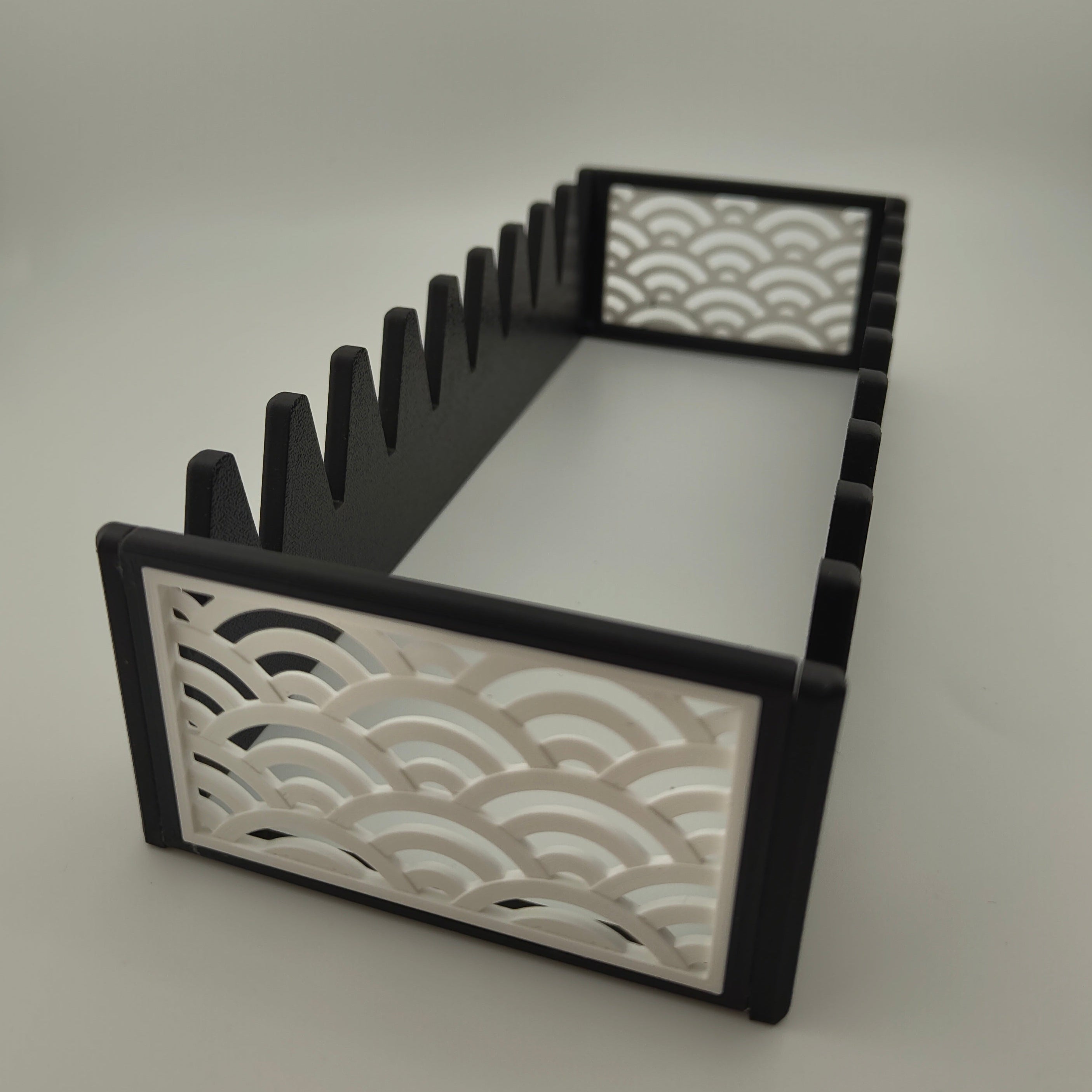 A black scissor organiser with a white Japanese wave pattern