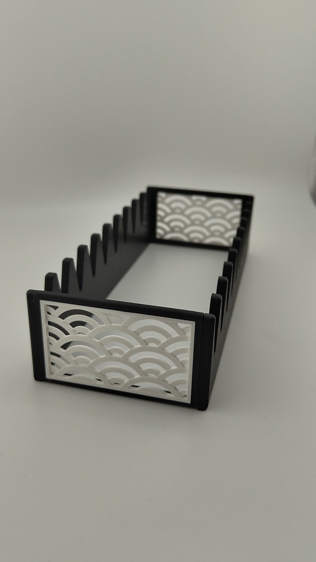 A black scissor organiser with a white Japanese wave pattern